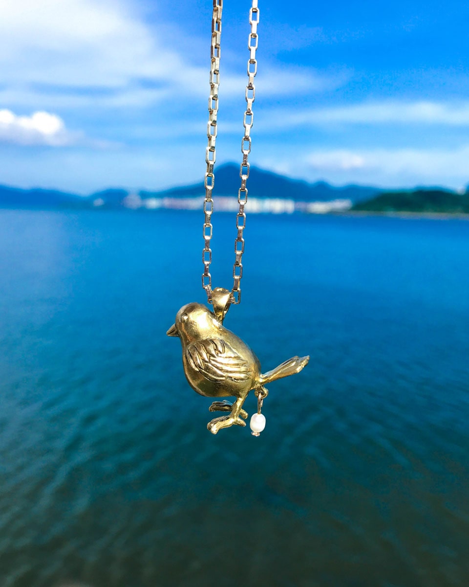 handmade brass pooping bird pendant that poops out a freshwater pearl, by fake plastic love