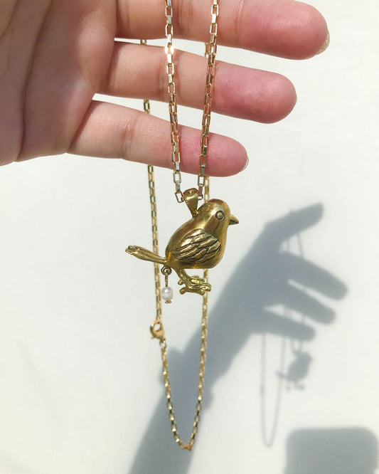 handmade brass pooping bird pendant that poops out a freshwater pearl, by fake plastic love