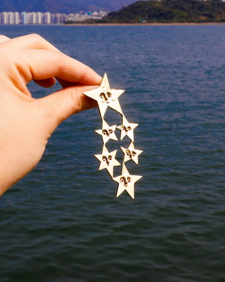 A Mega Puke of Stars’ bold earring — an expansive, intricate network of star characters, each with expressive faces, a statement celestial jewellery . Handcrafted with lost-wax casting in brass, this statement piece merges humour and heartache for those who wear their stories