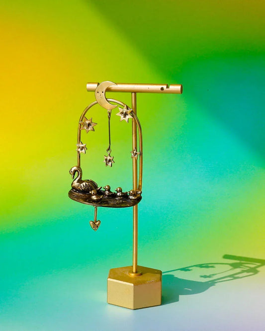 The Swan That Swam the Other Way’ handmade kinetic earrings — a three-part design featuring a moonlit lake, a swan family with four babies (one movable), and a dangling star. Wax-carved and cast in brass, this unique piece embodies memories of solitude and growth.