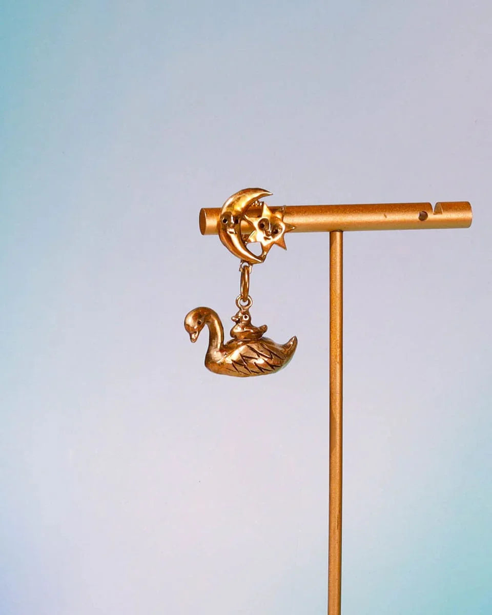 The Swan, cygnet and the moon earring featuring a baby swan riding on its parent, topped with a smiling moon and star. Handmade with lost-wax casting in brass—a tiny ode to love and cosmic connections