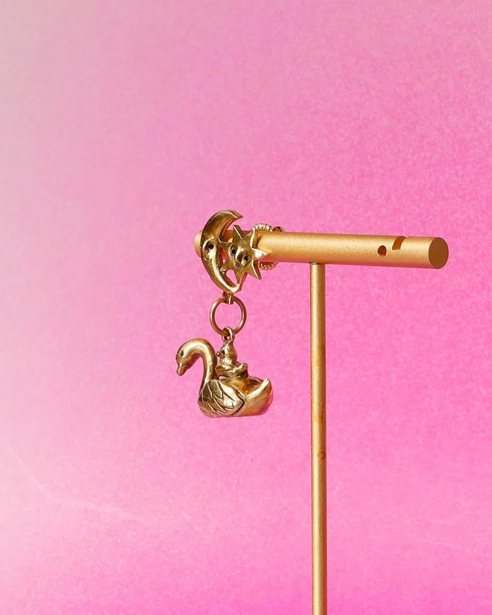 The Swan, cygnet and the moon earring featuring a baby swan riding on its parent, topped with a smiling moon and star. Handmade with lost-wax casting in brass—a tiny ode to love and cosmic connections
