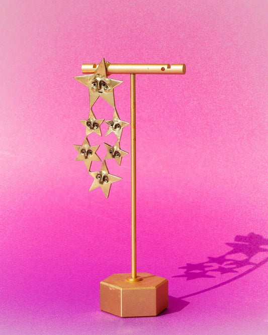 A Mega Puke of Stars’ bold earring — an expansive, intricate network of star characters, each with expressive faces, a statement celestial jewellery . Handcrafted with lost-wax casting in brass, this statement piece merges humour and heartache for those who wear their stories