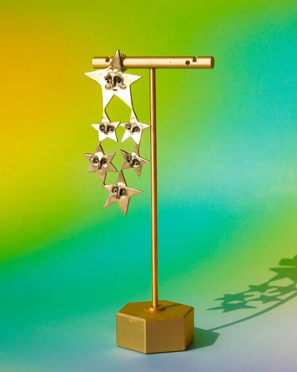 A Mega Puke of Stars’ bold earring — an expansive, intricate network of star characters, each with expressive faces, a statement celestial jewellery. Handcrafted with lost-wax casting in brass, this statement piece merges humour and heartache for those who wear their stories