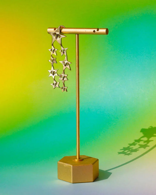 A Puke of Stars handmade earrings — a whimsical cluster of tiny stars, each with a unique face, linking together like cosmic characters. Wax-carved and cast in brass, this one-of-a-kind celestial jewellery piece celebrates connections with playful melancholy