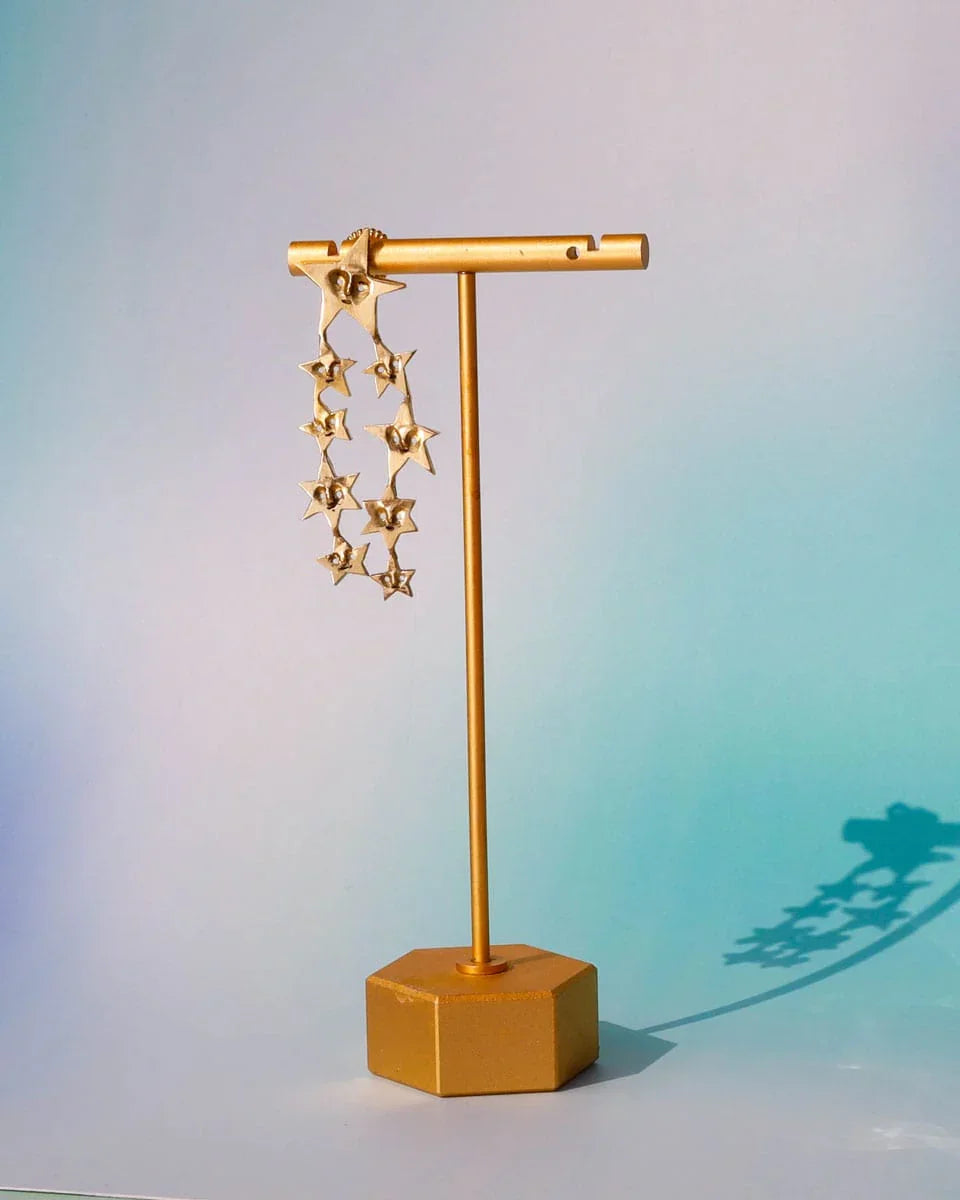 A Puke of Stars handmade earrings — a whimsical cluster of tiny stars, each with a unique face, linking together like cosmic characters. Wax-carved and cast in brass, this one-of-a-kind celestial jewellery piece celebrates connections with playful melancholy
