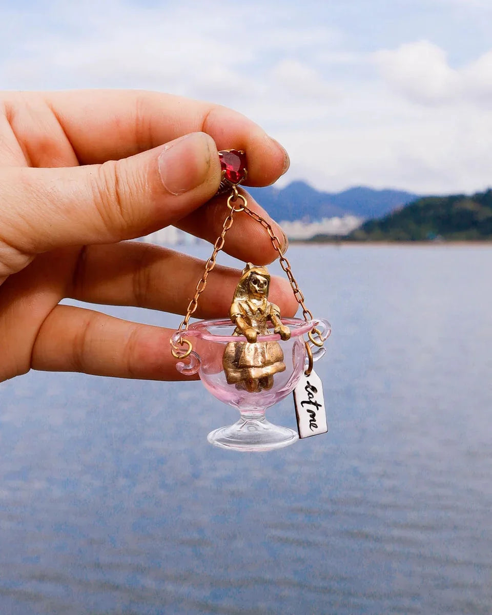 Handmade Alice in Wonderland earring/pendant with glass bowl, brass figure, and "Eat Me" vitreous enamel tag, handmade by fake plastic love