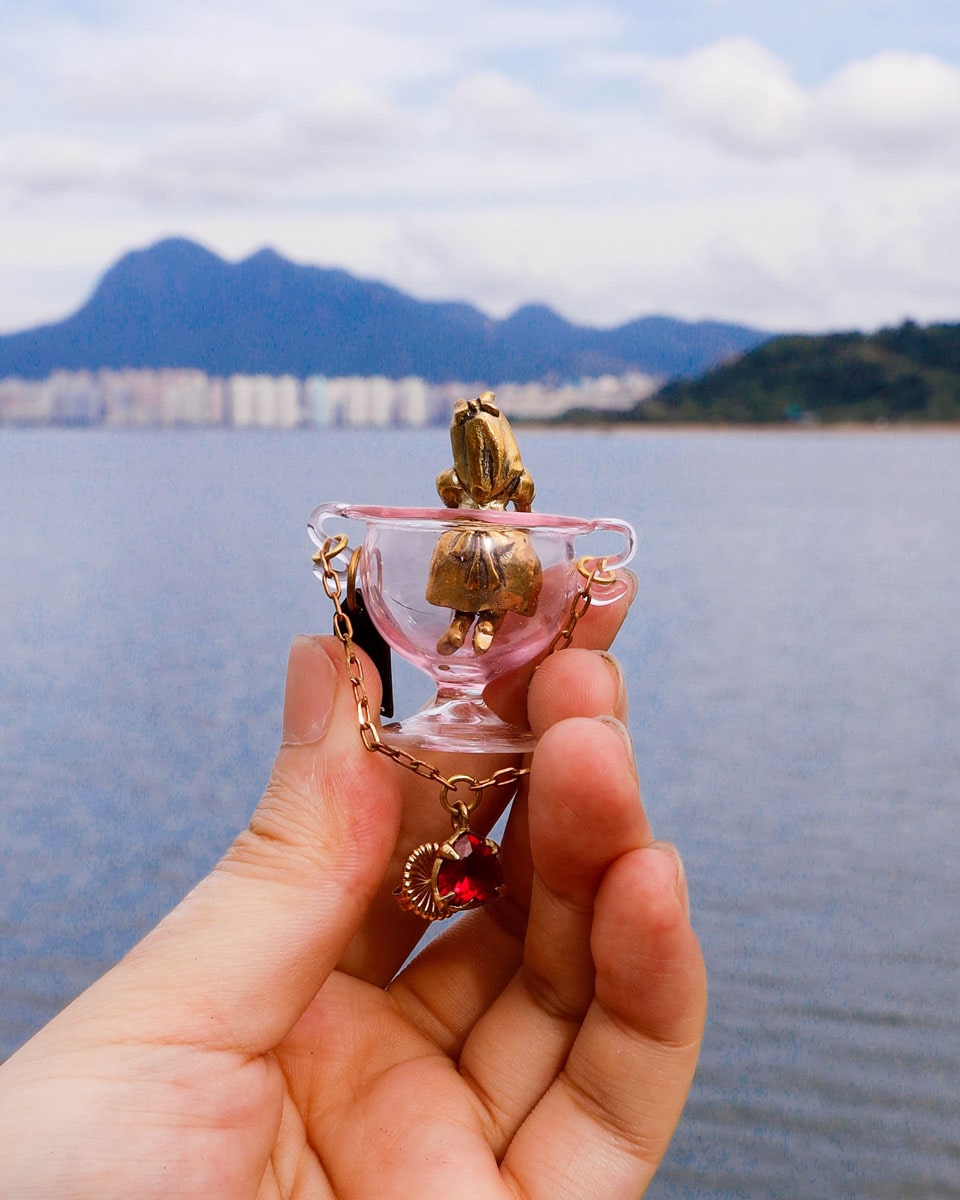 Handmade Alice in Wonderland earring/pendant with glass bowl, brass figure, and "Eat Me" vitreous enamel tag, handmade by fake plastic love