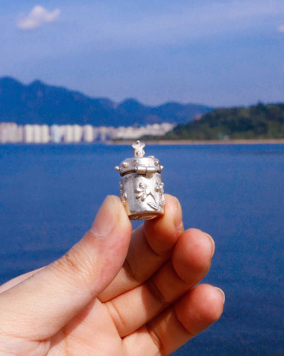A solid sterling silver container locket pendant with flower, hand-carved with wax cast into silver, with a functional hinged lid. Handmade by fake plastic love