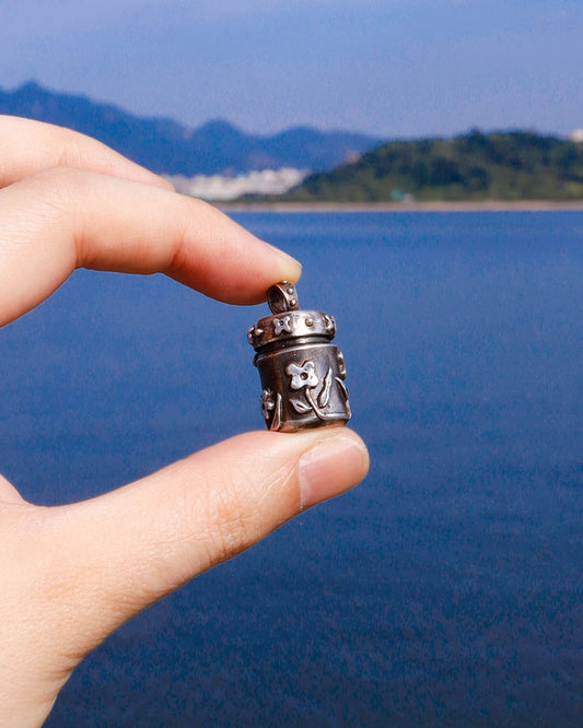 A solid sterling silver container locket pendant with floral details in patina finish, hand-carved with wax cast into silver, with a functional hinged lid. Handmade by fake plastic love