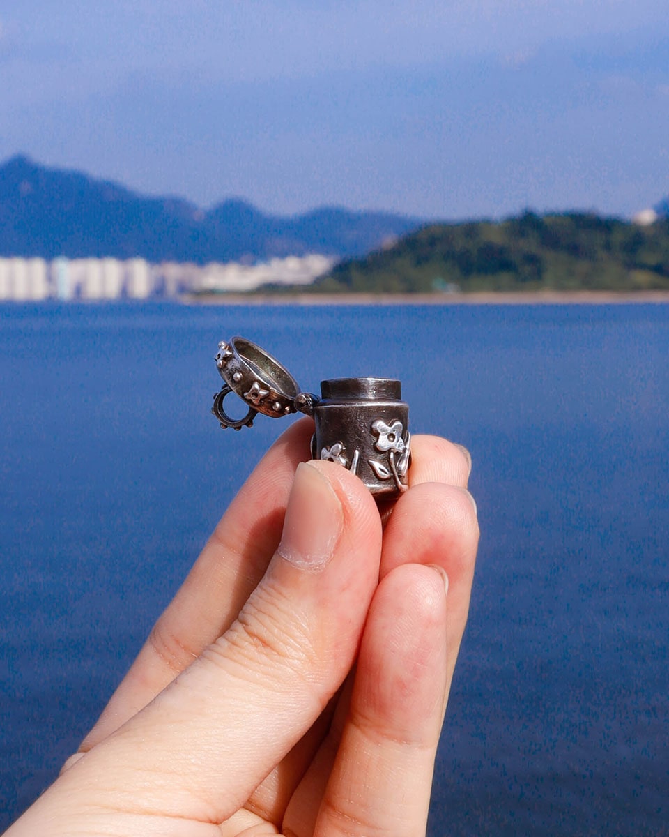 A solid sterling silver container locket pendant with floral details in patina finish, hand-carved with wax cast into silver, with a functional hinged lid. Handmade by fake plastic love