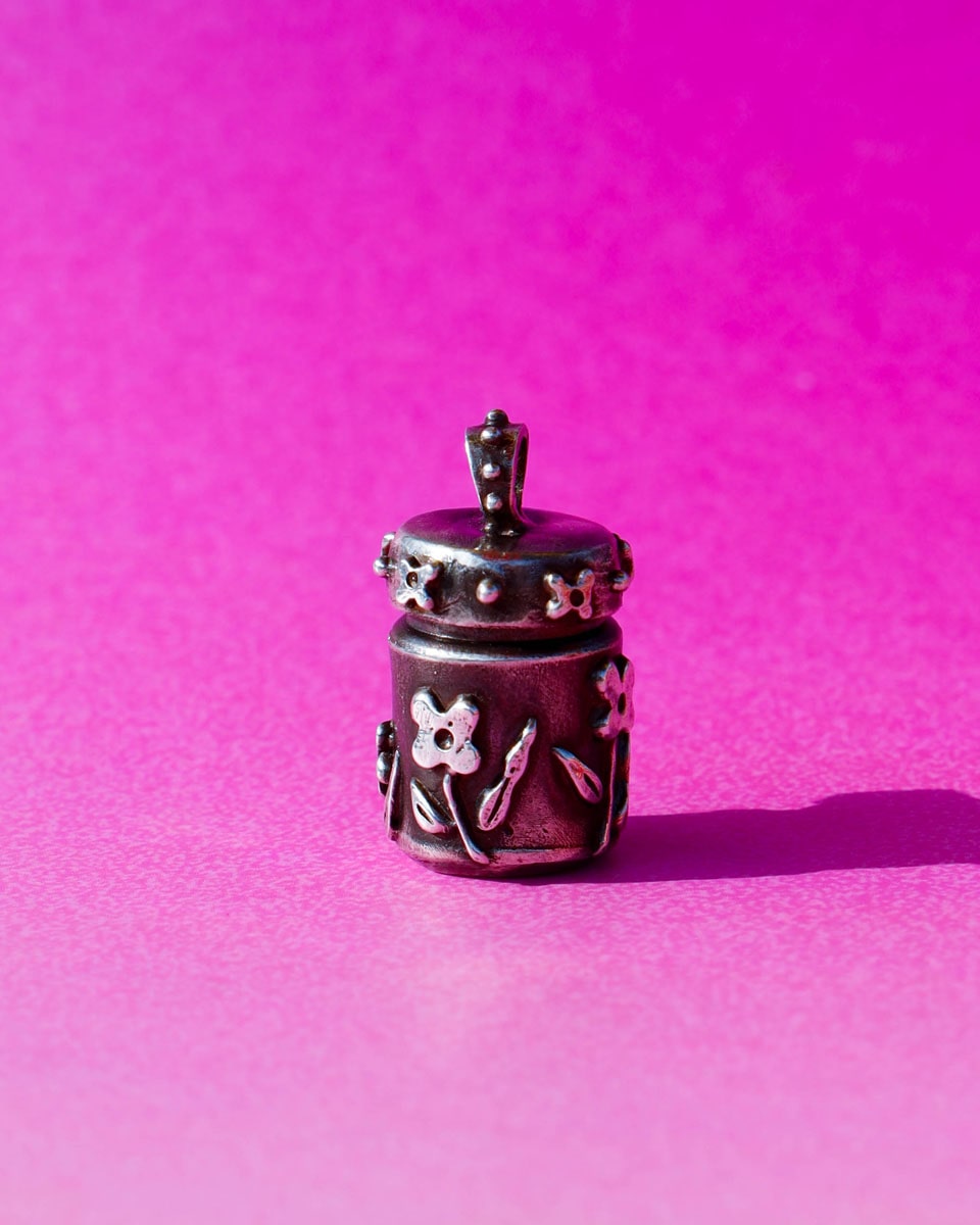 A solid sterling silver container locket pendant with floral details in patina finish, hand-carved with wax cast into silver, with a functional hinged lid. Handmade by fake plastic love
