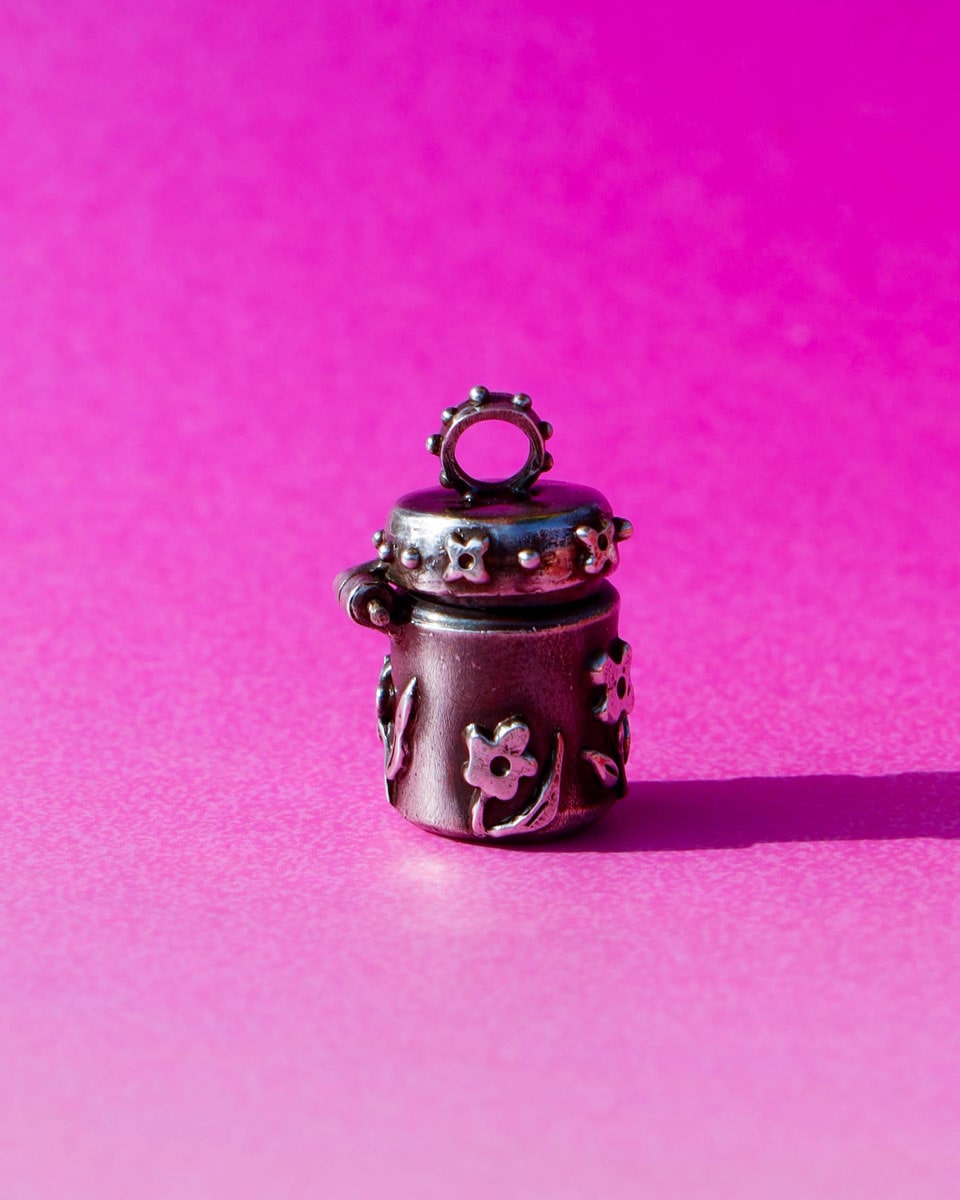 A solid sterling silver container locket pendant with floral details in patina finish, hand-carved with wax cast into silver, with a functional hinged lid. Handmade by fake plastic love
