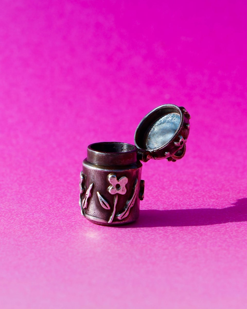 A solid sterling silver container locket pendant with floral details in patina finish, hand-carved with wax cast into silver, with a functional hinged lid. Handmade by fake plastic love