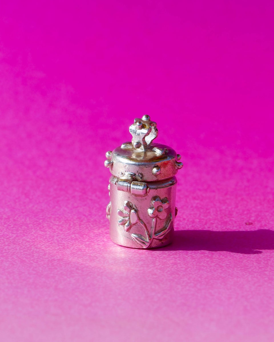 A solid sterling silver container locket pendant with flower, hand-carved with wax cast into silver, with a functional hinged lid. Handmade by fake plastic love