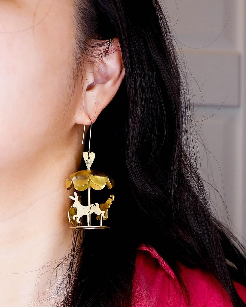 A kinetic miniature carousel earring, handmade from brass sheets, handcrafted jewellery, by fake plastic love