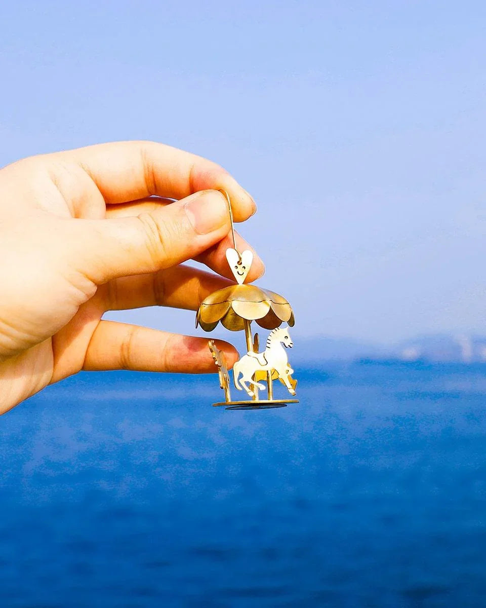 A kinetic miniature carousel earring, handmade from brass sheets, handcrafted jewellery, by fake plastic love