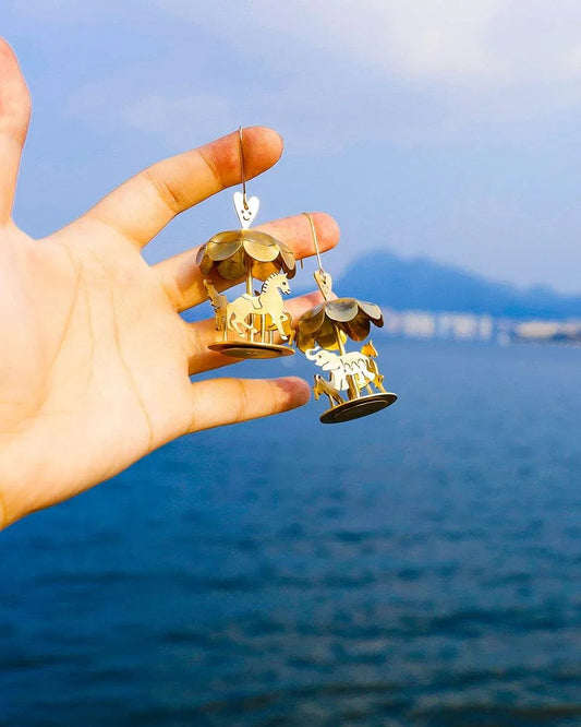 A kinetic miniature carousel earring, handmade from brass sheets, handcrafted jewellery, by fake plastic love