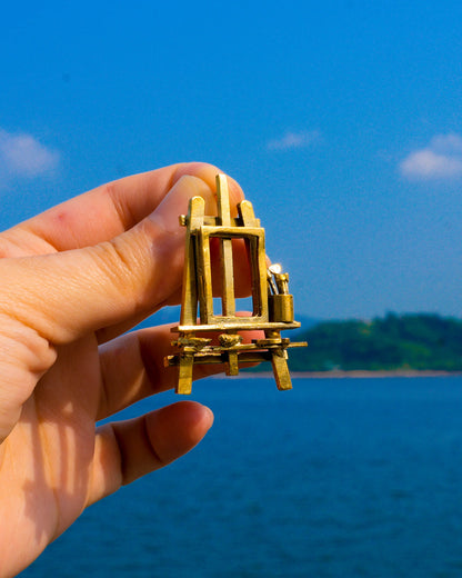 Miniature painting stand earring in brass with artist easel, brushes, palette, and paint tubes