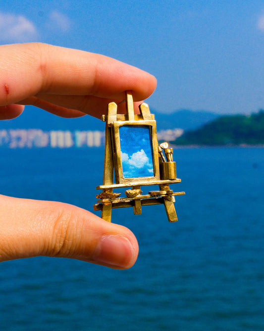 Miniature painting stand earring in brass with artist easel, brushes, palette, and paint tubes