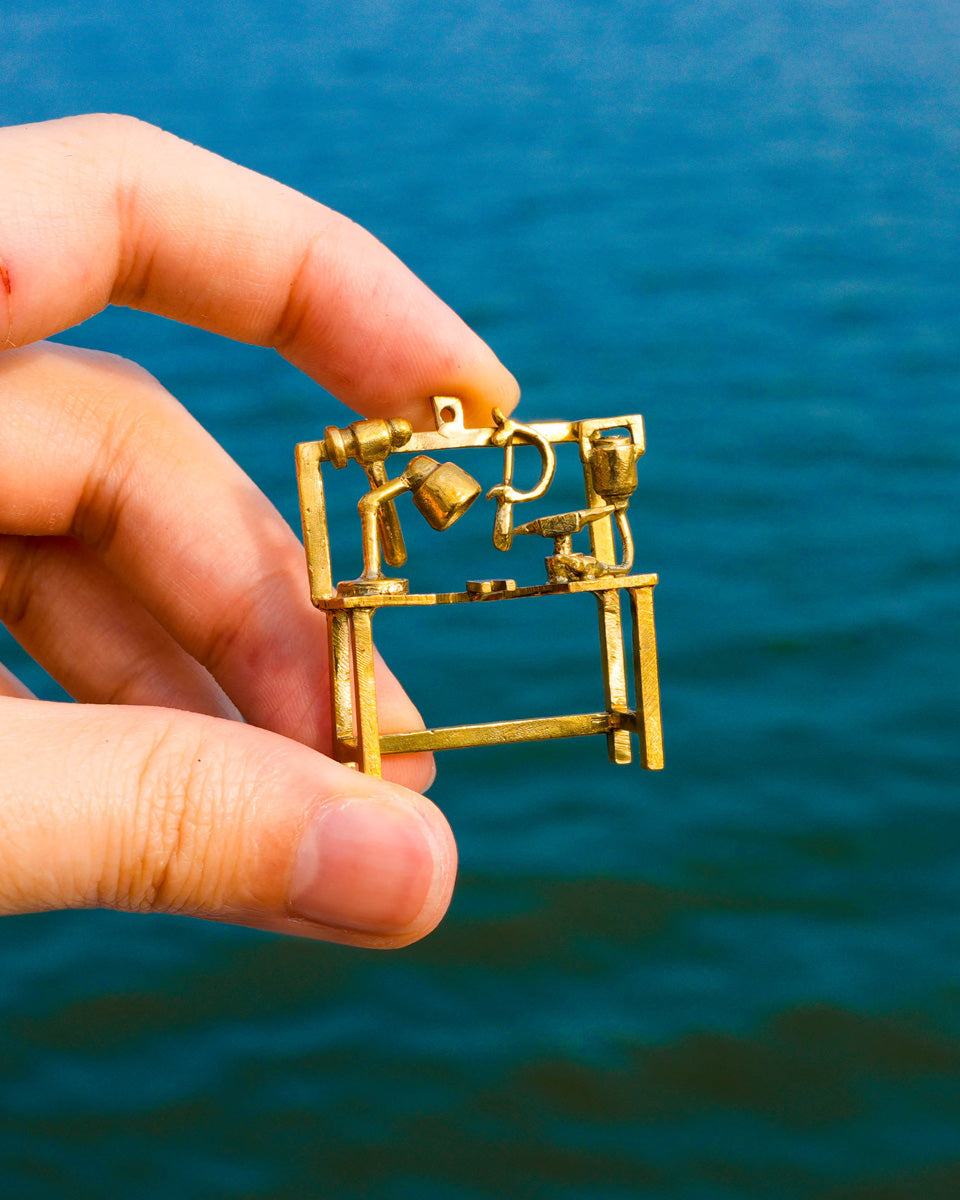 Miniature jeweller’s bench earring in brass with bench peg and tools, handcrafted wearable sculpture