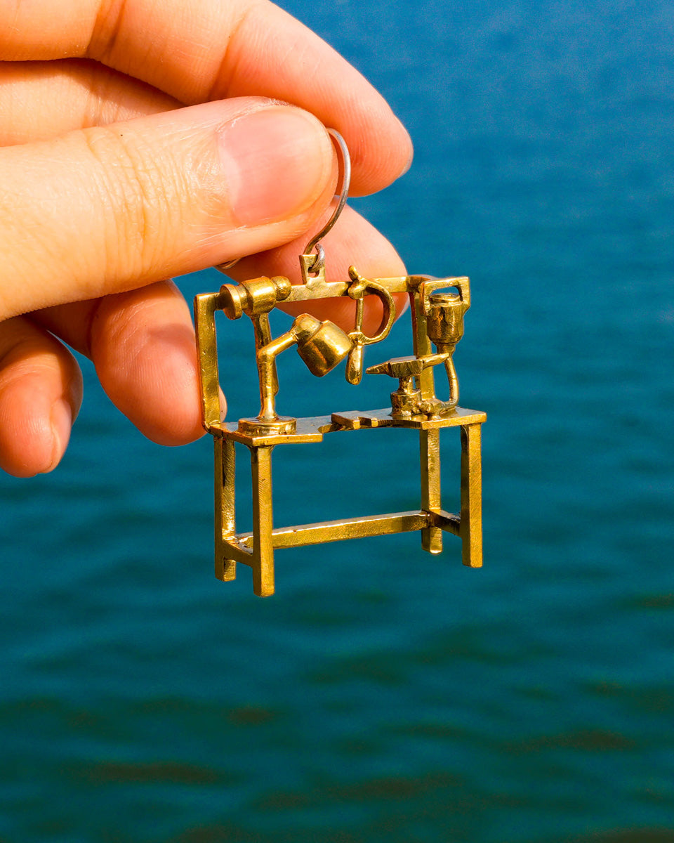 Miniature jeweller’s bench earring in brass with bench peg and tools, handcrafted wearable sculpture