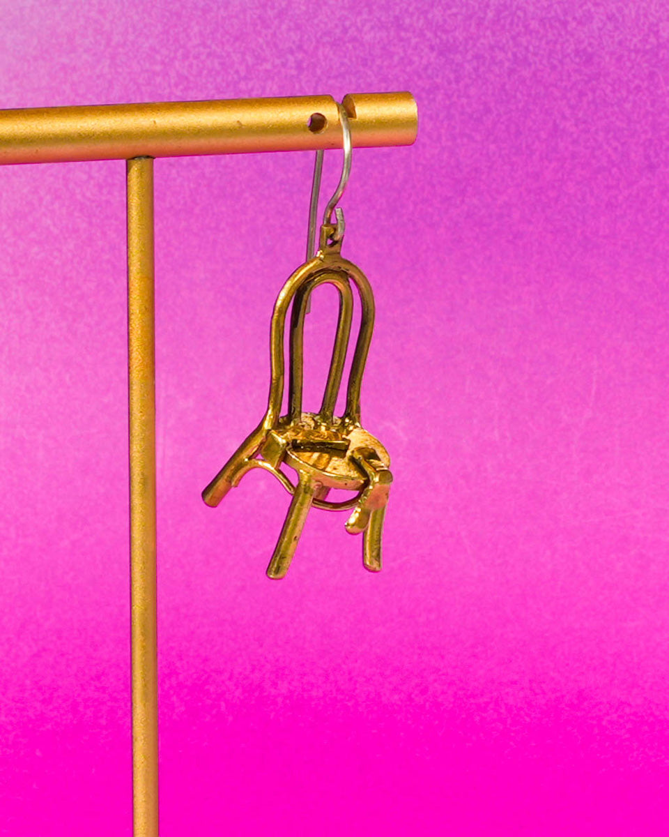 close up of miniature chair with socks brass earring, handcrafted wearable sculpture