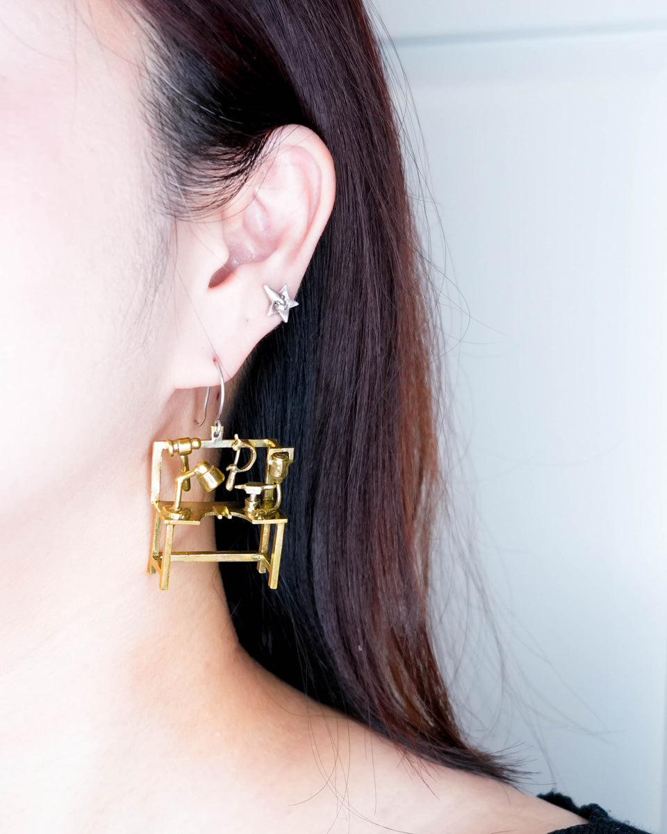 Miniature jeweller’s bench statement earring worn on ear, handcrafted studio-inspired jewelry