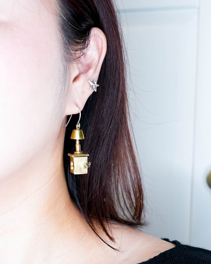 close up of wearing miniature bedside table locket earring with hinge opening in brass