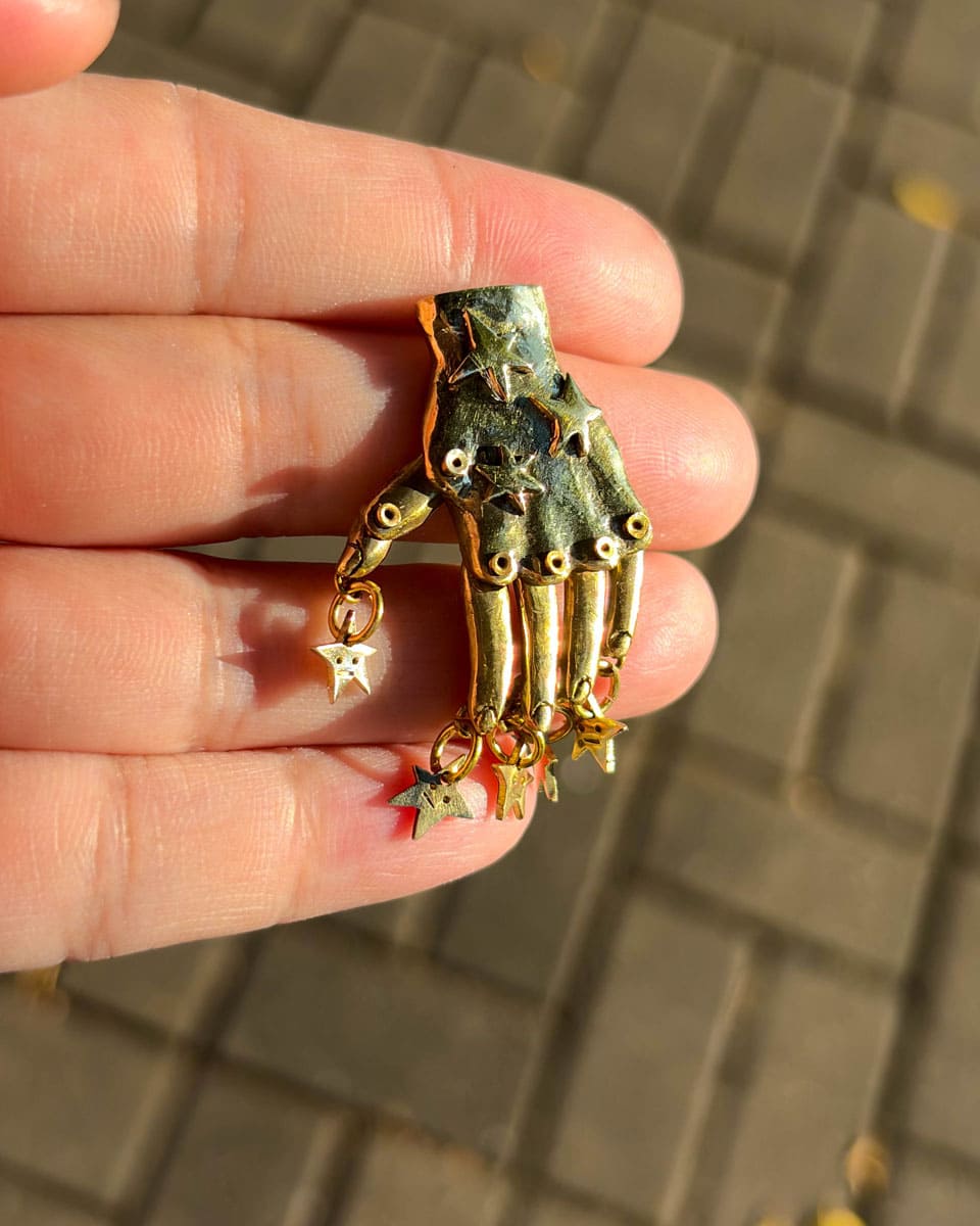 Handmade articulated hand star earring in brass with five dangling stars by Fake Plastic Love