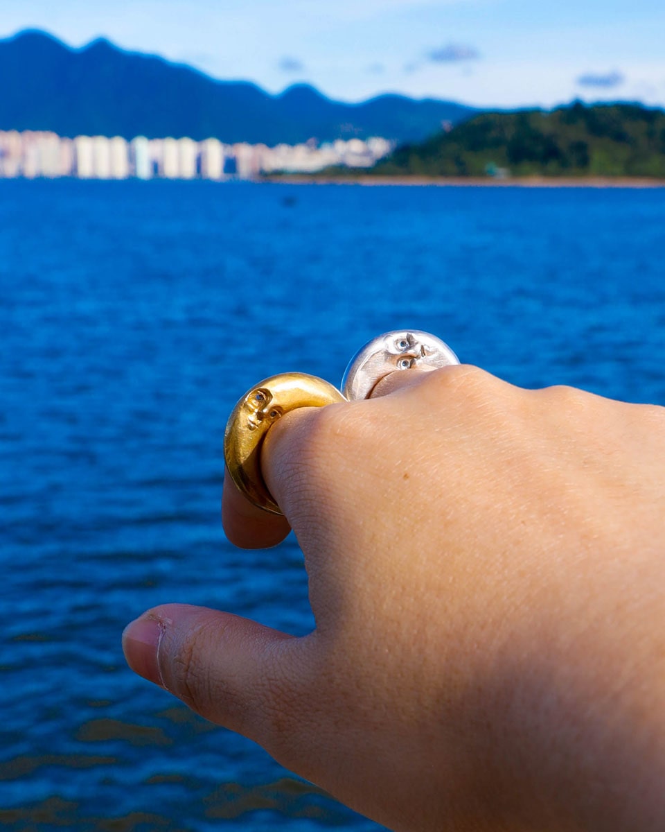 woman hand wearing Solid brass and sterling silver Celestial full Moon Rings for Mid-Autumn Festival, featuring moon faces on the sides symbolizing family reunion and harmony