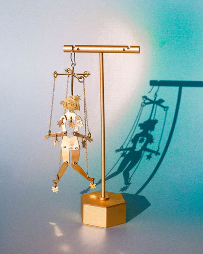 Articulated brass puppet earring "The Person Controlled by the Stars" with moving handsaw joints