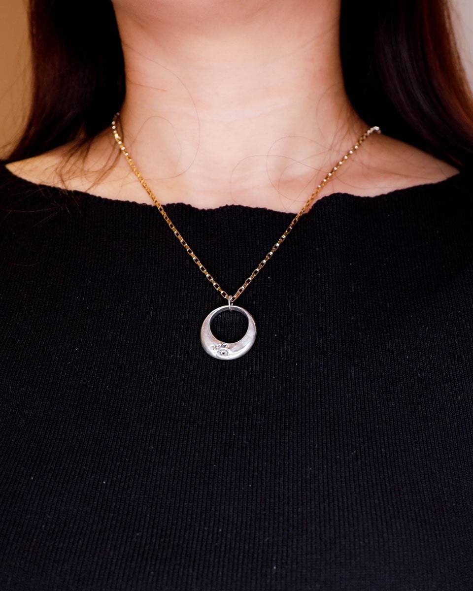 Solid sterling silver Celestial full Moon pendant on woman for Mid-Autumn Festival, featuring moon faces on the sides symbolizing family reunion and harmony