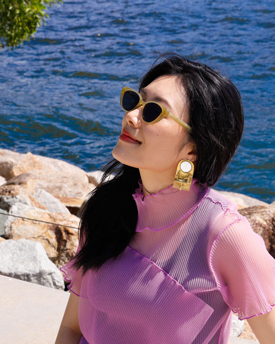 girl wearing a miniature sink statement earring, handcrafted in brass with a functional mirror