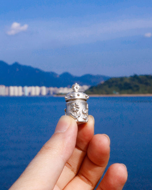 A solid sterling silver container locket pendant with flower, hand-carved with wax cast into silver, with a functional hinged lid. Handmade by fake plastic love