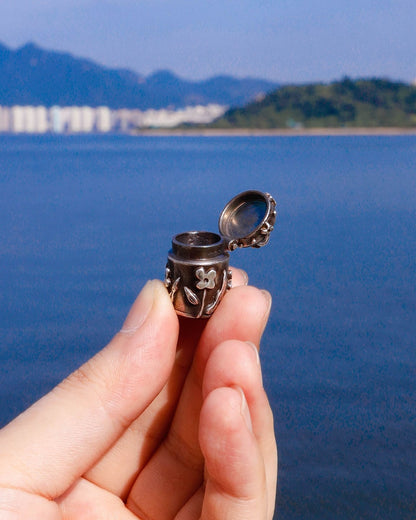 A solid sterling silver container locket pendant with floral details in patina finish, hand-carved with wax cast into silver, with a functional hinged lid. Handmade by fake plastic love