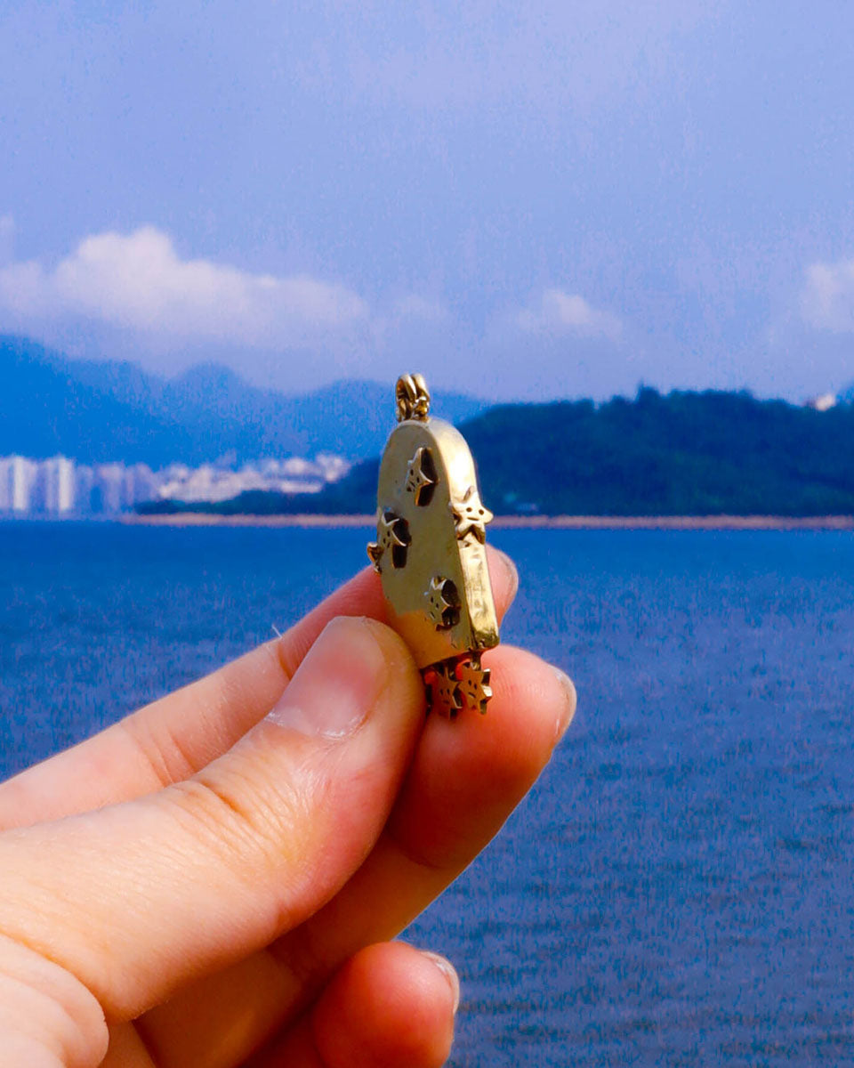 the side detail of a brass arched-shaped charm with stars design, handmade jewellery with a functional mirror