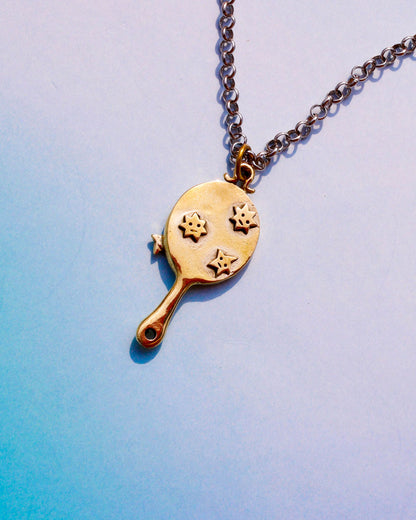 Gold necklace with a pendant shaped like a tiny hand mirror with stars motifs