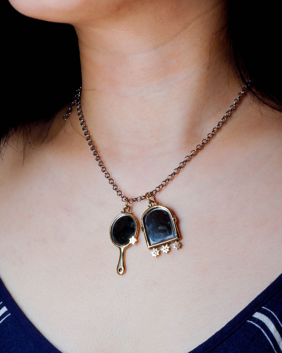 Necklace with mirror-shaped pendants on a person's neck