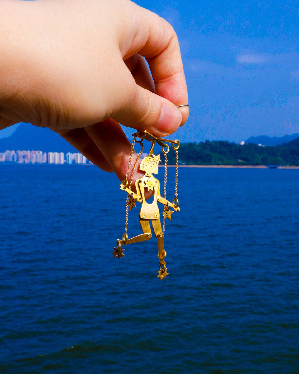 Mini articulated puppet earrings in brass, smaller version of “The Person Controlled By The Stars”, handmade sculptural jewelry