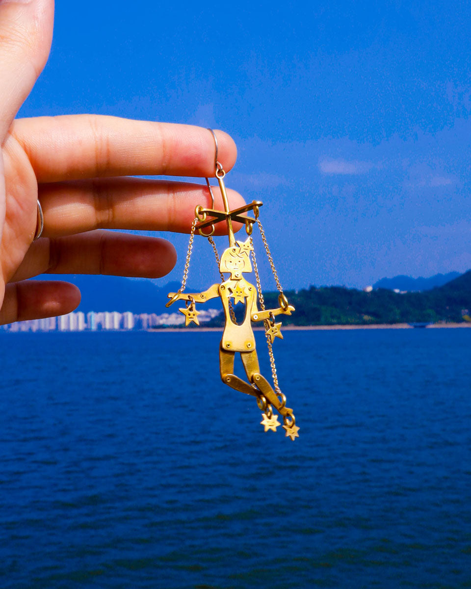 Mini articulated puppet earrings in brass, smaller version of “The Person Controlled By The Stars”, handmade sculptural jewelry