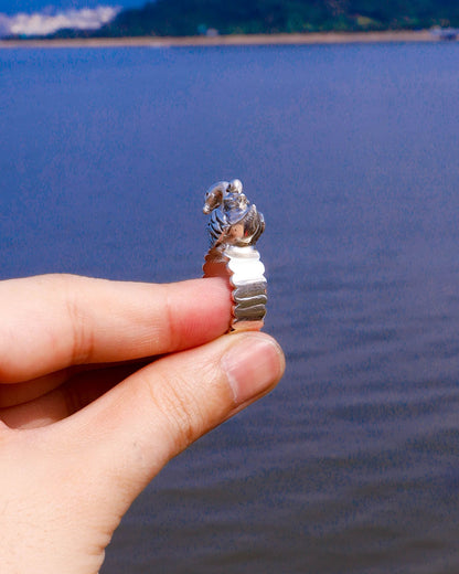 side view of Handmade swan ring in sterling silver photographed beside water