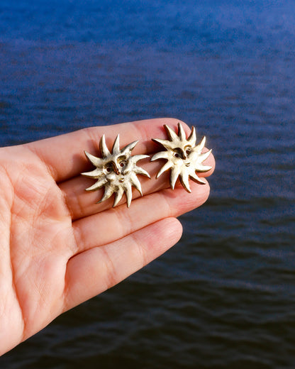 a pair of solid brass sun earrings, handmade studs