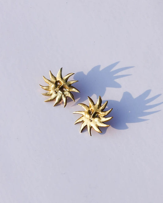 a pair of solid brass sun earrings, handmade studs